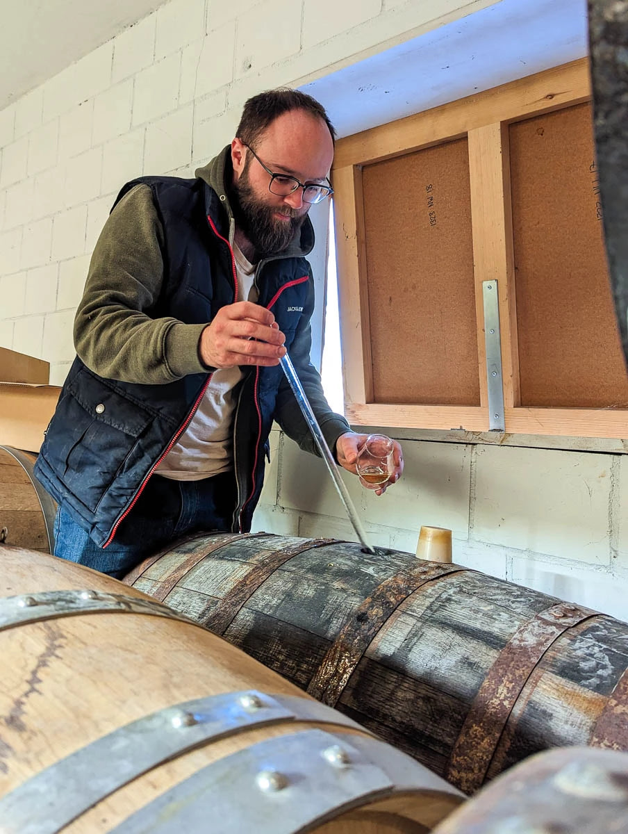 Raphael nimmt eine Probe aus einem Whiskyfass