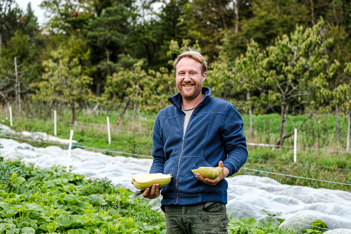 Michael mit einem Kürbis in den Händen auf dem Feld
