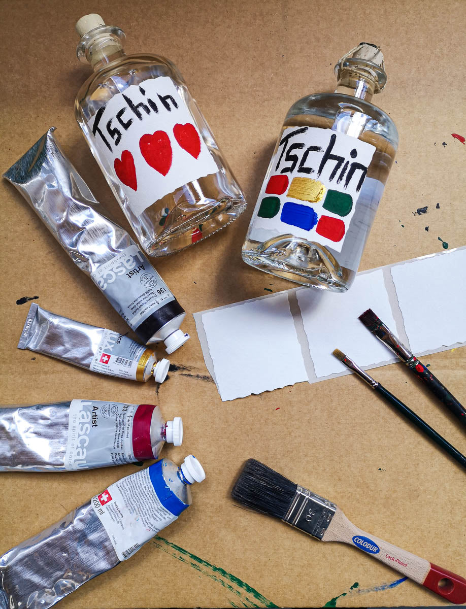 Pinsel, Farben und zwei Flaschen Tschin mit farbigen Etiketten
